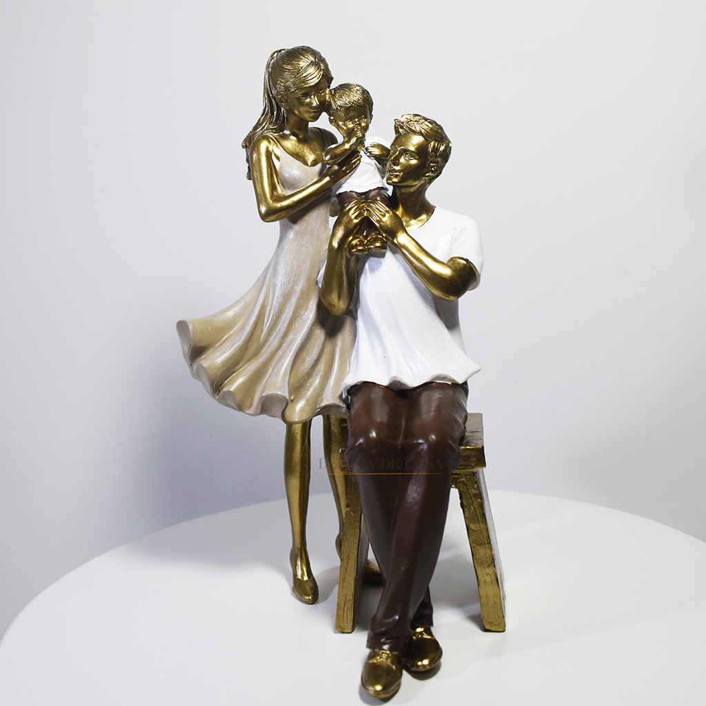 Escultura decorativa em resina representando pai sentado, mãe em pé e filho ao centro, simbolizando amor, proteção e união familiar.