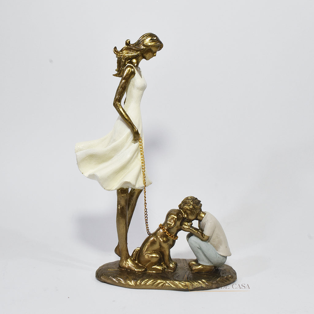 Estatueta decorativa de resina representando uma mãe segurando a coleira de um cachorro, enquanto seu filho se ajoelha e interage com o pet, simbolizando amor e conexão familiar.