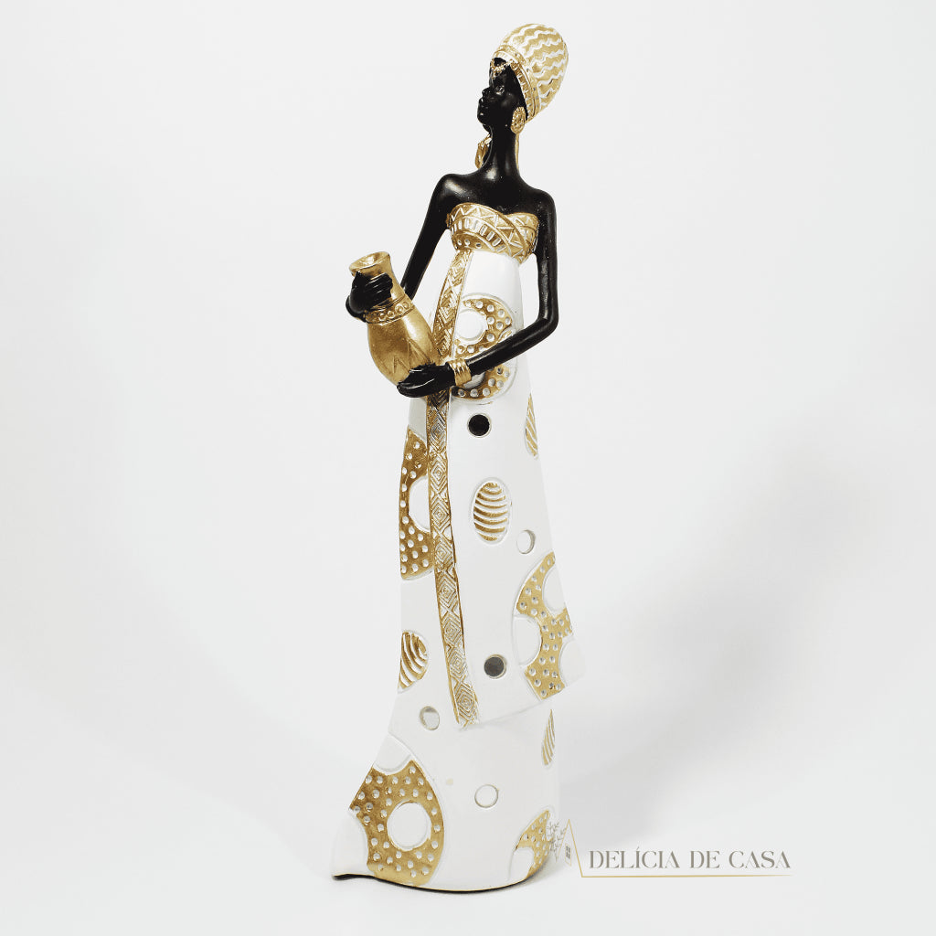 Estátua decorativa de mulher africana em resina nas cores branco, dourado e preto, com trajes típicos, medindo 32,5 cm de altura — peça elegante e cultural para decoração de interiores.
