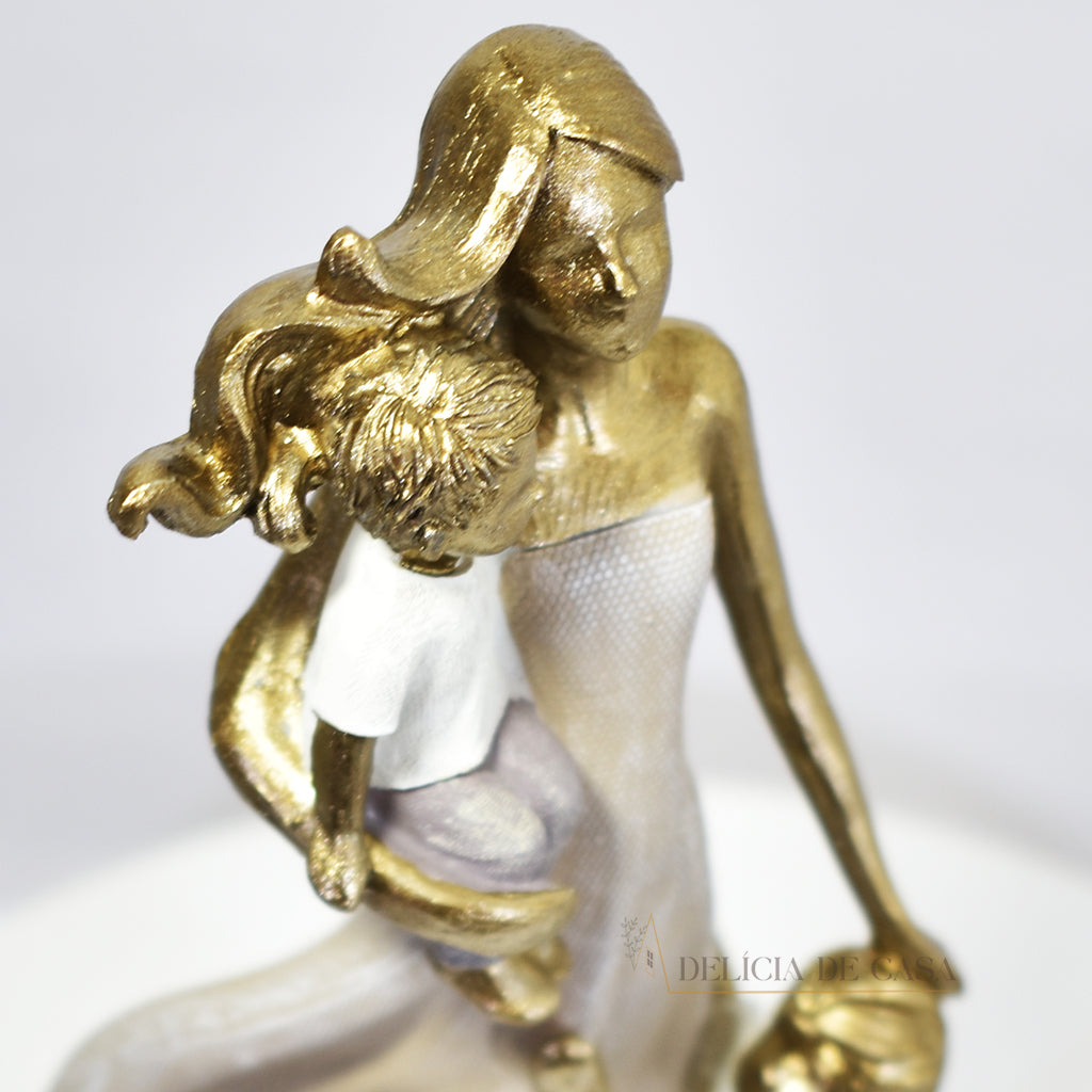 Escultura de mãe com dois filhos em resina dourada. Uma peça elegante e simbólica que representa o amor familiar, ideal para decorar ambientes ou presentear em ocasiões especiais.