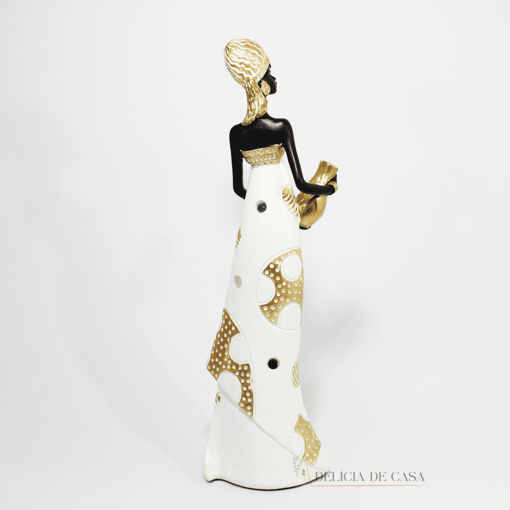 Estátua decorativa de mulher africana em resina nas cores branco, dourado e preto, com trajes típicos, medindo 32,5 cm de altura — peça elegante e cultural para decoração de interiores.