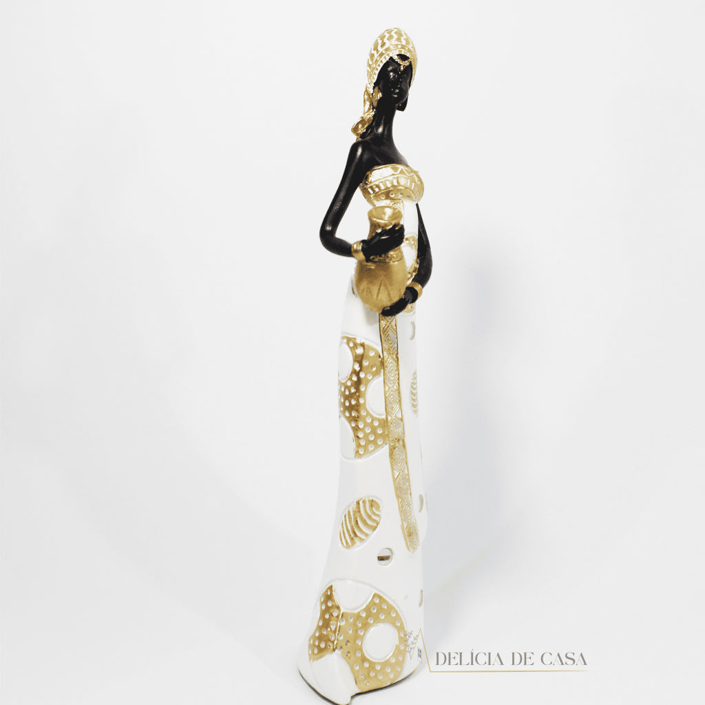 Estátua decorativa de mulher africana em resina nas cores branco, dourado e preto, com trajes típicos, medindo 32,5 cm de altura — peça elegante e cultural para decoração de interiores.