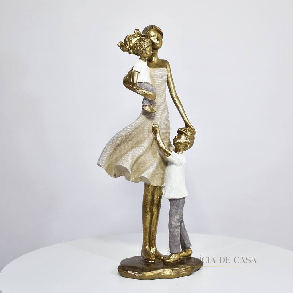 Escultura de mãe com dois filhos em resina dourada. Uma peça elegante e simbólica que representa o amor familiar, ideal para decorar ambientes ou presentear em ocasiões especiais.