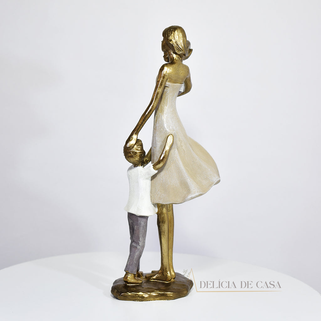 Escultura de mãe com dois filhos em resina dourada. Uma peça elegante e simbólica que representa o amor familiar, ideal para decorar ambientes ou presentear em ocasiões especiais.