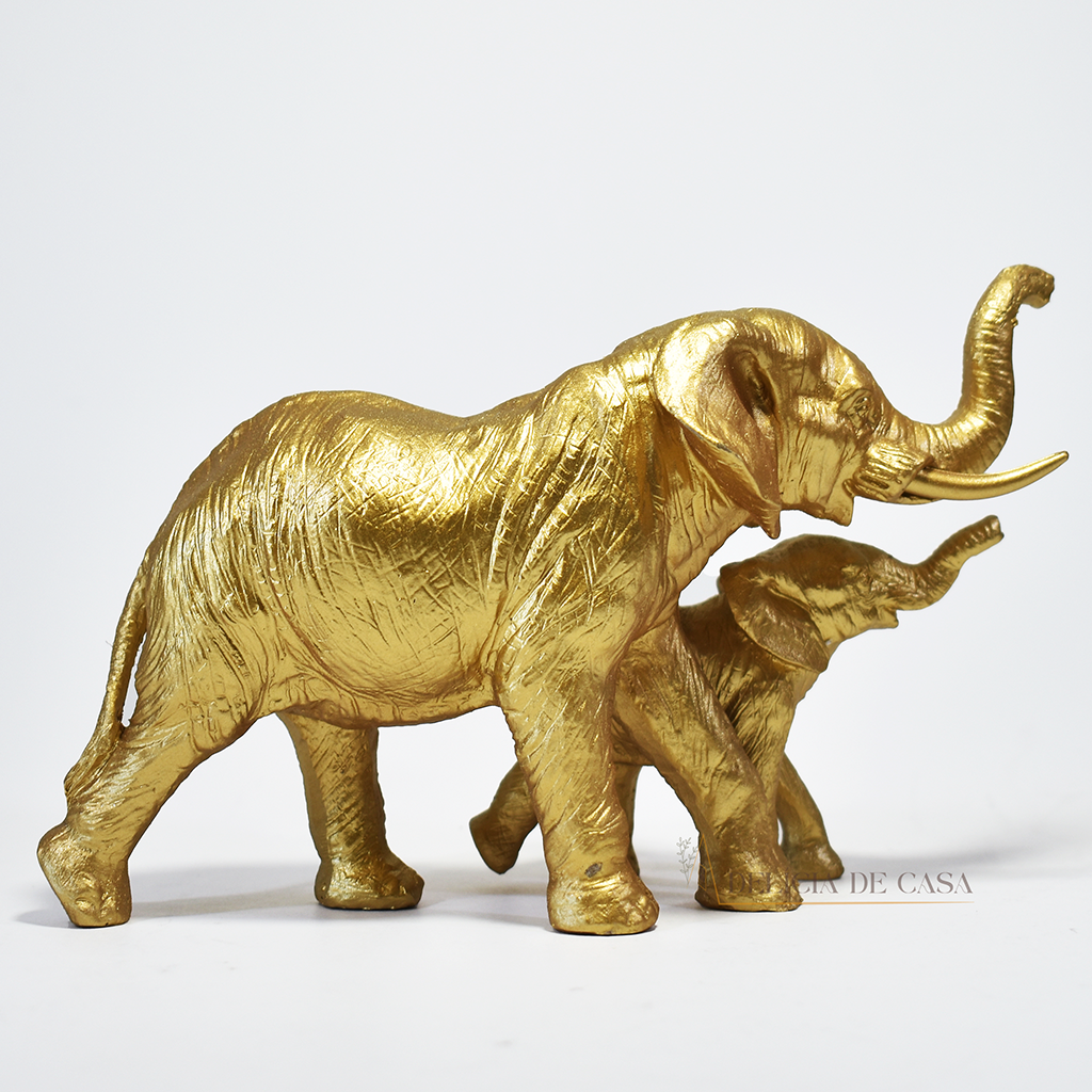Escultura decorativa de elefante com filhote em resina dourada, simbolizando proteção, união familiar e prosperidade.