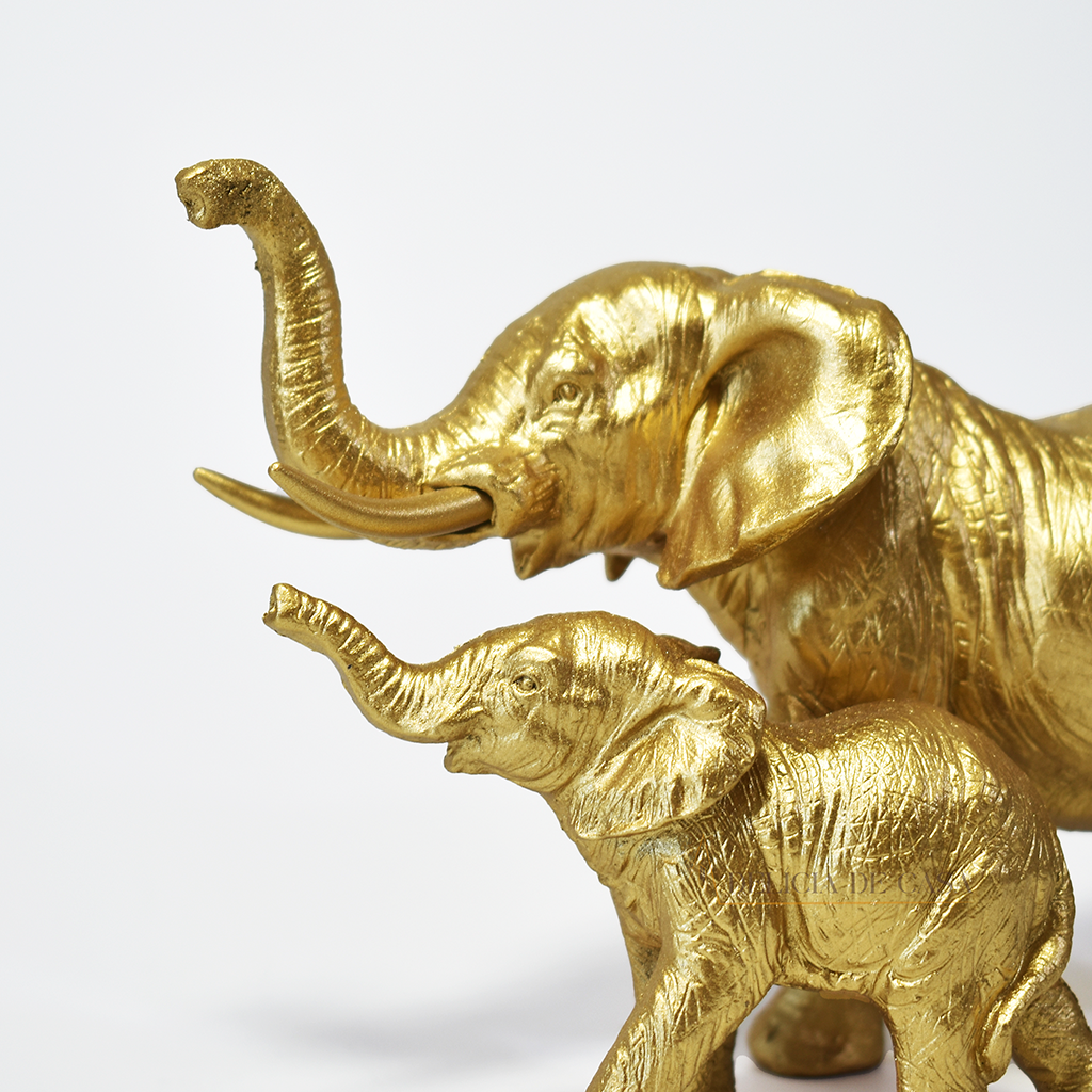 Escultura decorativa de elefante com filhote em resina dourada, simbolizando proteção, união familiar e prosperidade.