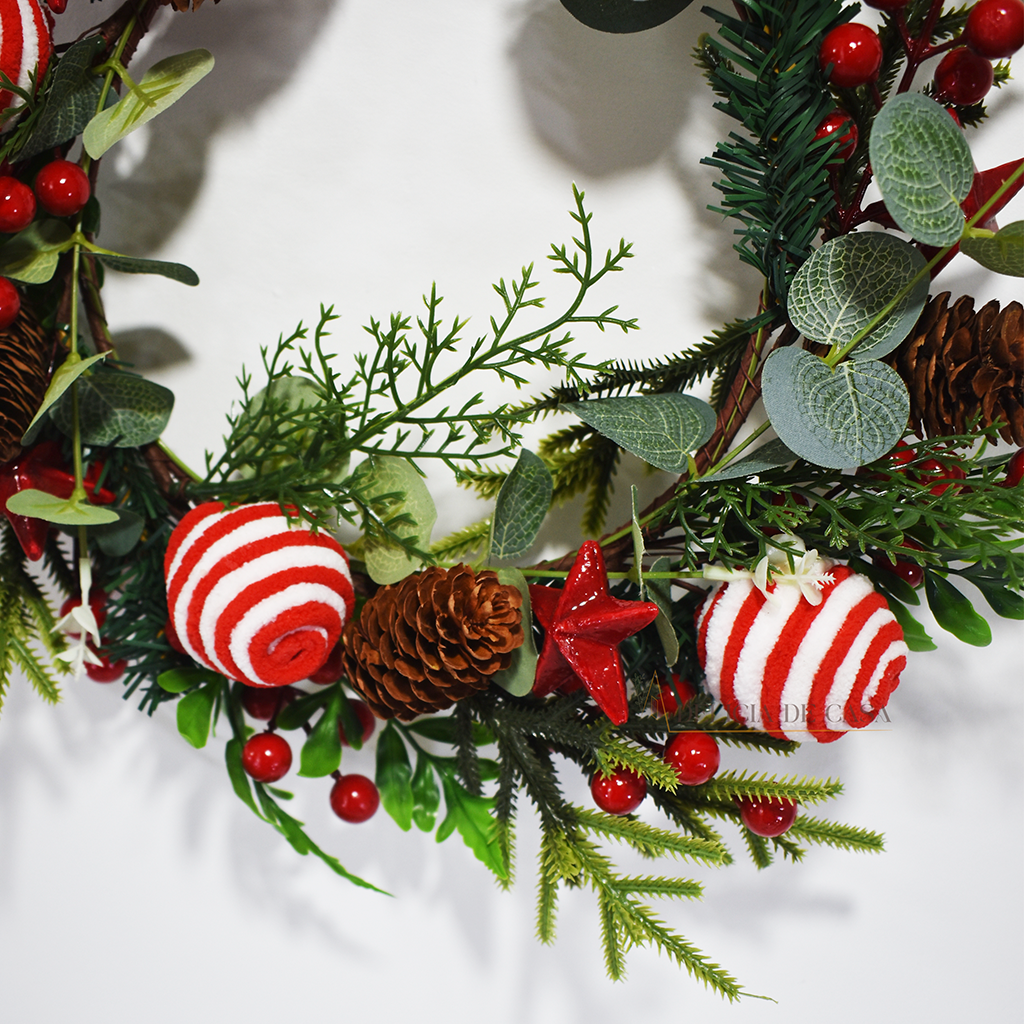 Guirlanda de Natal decorativa com bolas vermelhas e brancas, pinhas e folhagens verdes, ideal para pendurar na porta ou parede e decorar a casa no Natal.