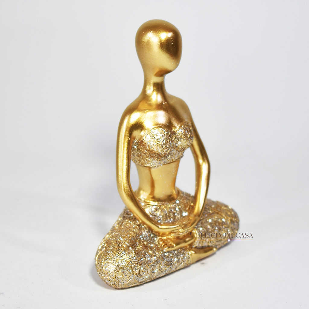 Trio de estátuas douradas com glitter representando posturas de ioga, ideal para decoração zen e ambientes de meditação.