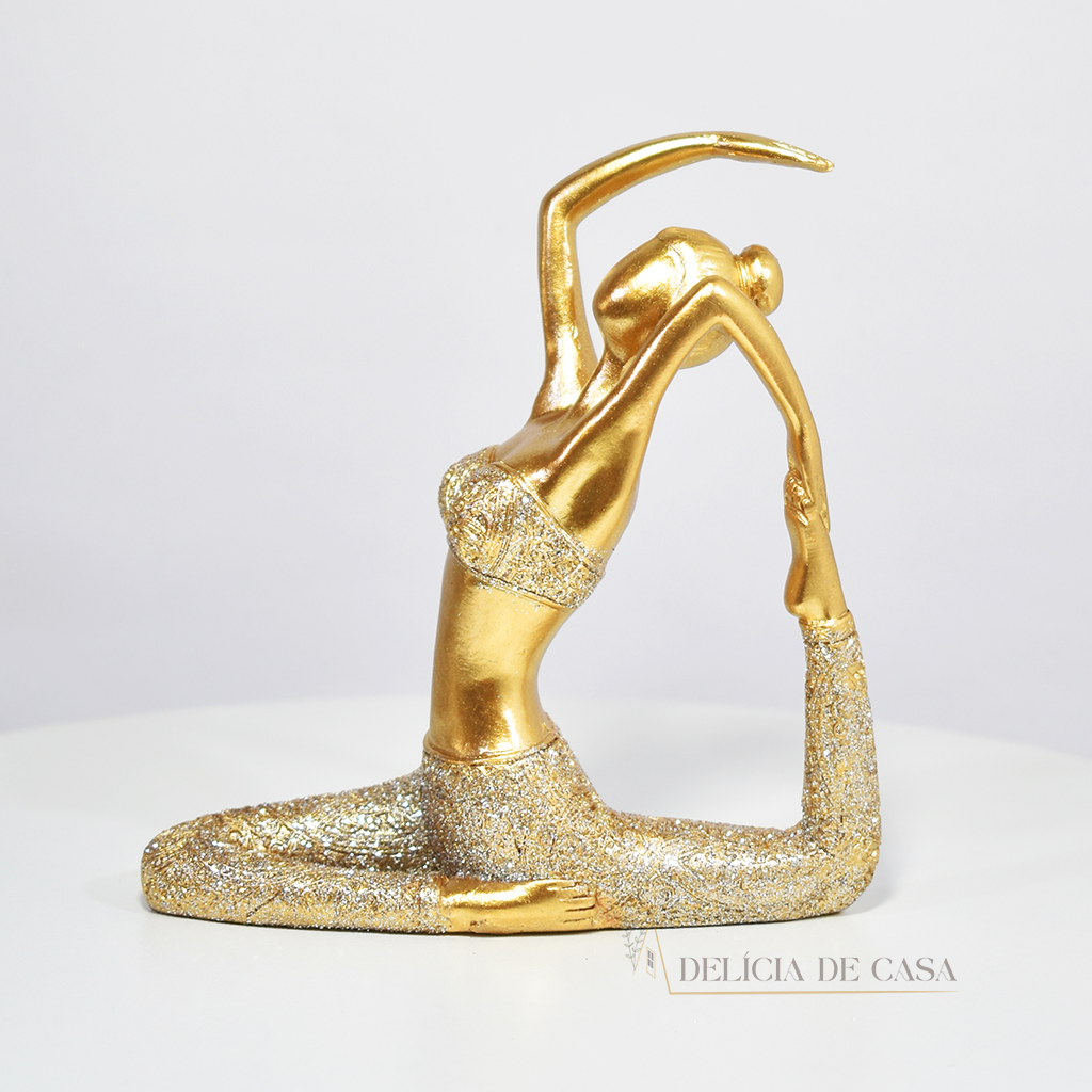 Escultura de mulher em posição de yoga com acabamento dourado e glitter. Uma peça decorativa que une elegância e serenidade, perfeita para decorar ou presentear.