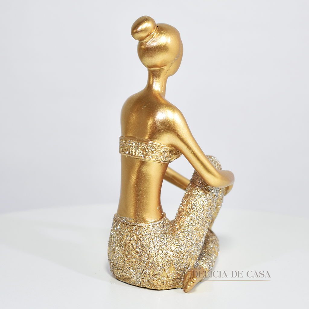 Escultura de mulher em posição de yoga com acabamento dourado e glitter. Uma peça decorativa que une elegância e serenidade, perfeita para decorar ou presentear.