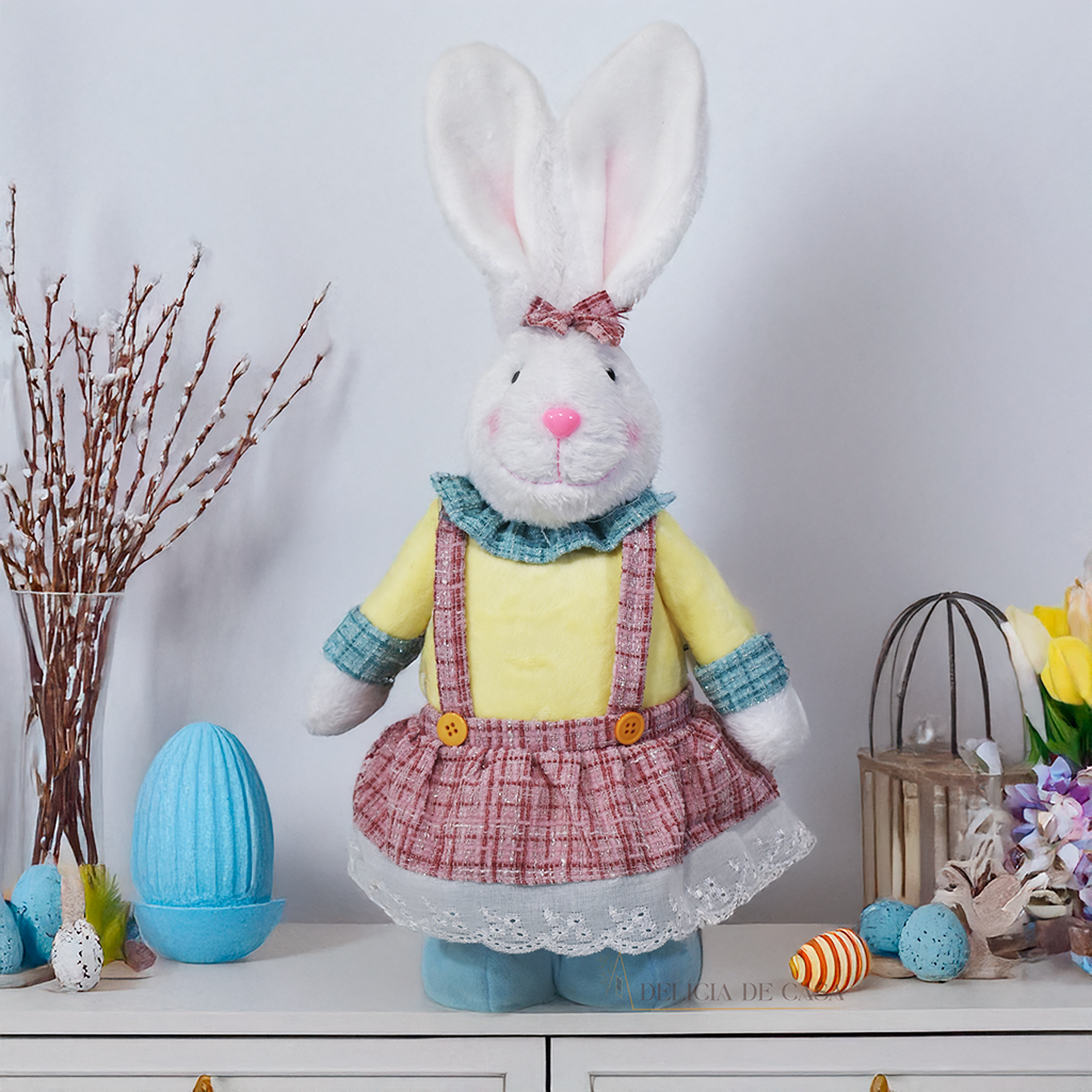 Coelha decorativa de Páscoa em pelúcia com vestido colorido, ideal para decoração de mesa, aparador e sala de estar.