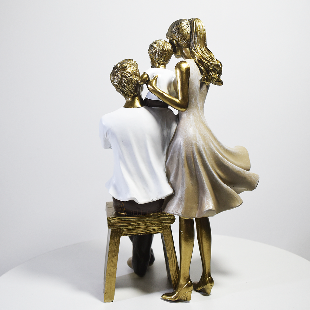 Escultura decorativa em resina representando pai sentado, mãe em pé e filho ao centro, simbolizando amor, proteção e união familiar.