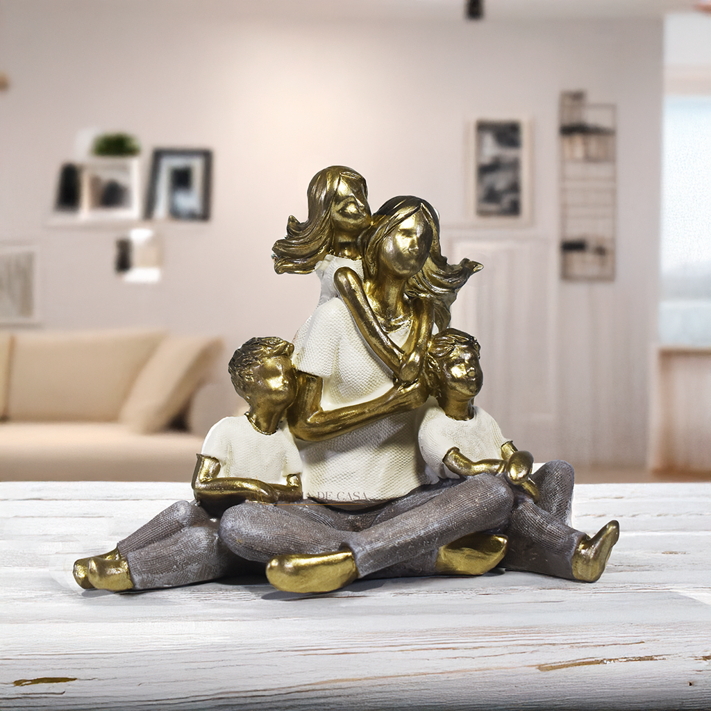 Escultura decorativa de mãe sentada com dois filhos e uma filha, confeccionada em resina com acabamento dourado, branco e cinza, medindo 15 x 11,5 x 8 cm.