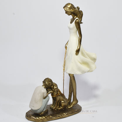 Estatueta decorativa de resina representando uma mãe segurando a coleira de um cachorro, enquanto seu filho se ajoelha e interage com o pet, simbolizando amor e conexão familiar.