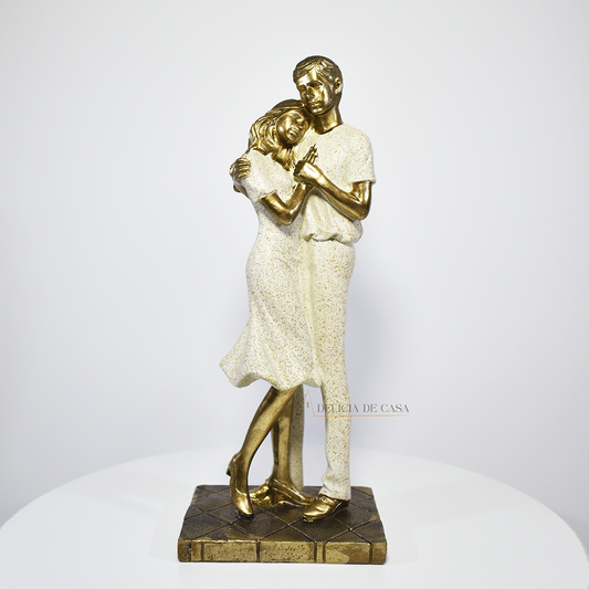 Estátua decorativa em resina dourada representando casal com filhos sentados em base artística, símbolo de união e amor familiar.