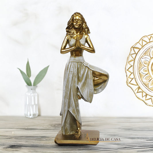 Estatueta decorativa de resina representando uma mulher em posição de yoga, equilibrada sobre uma perna, com as mãos unidas em prece, simbolizando paz e harmonia