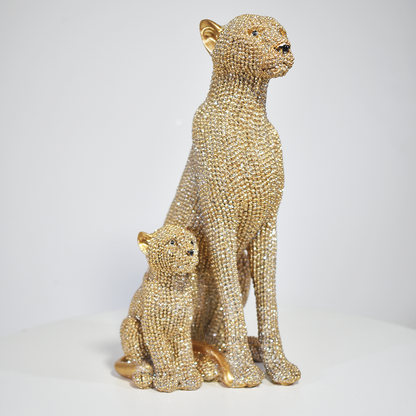Estatueta leoa com filhote dourada em resina, 19x12x9 cm. Uma peça sofisticada que simboliza proteção e vínculo familiar. Ideal para decoração e presente.