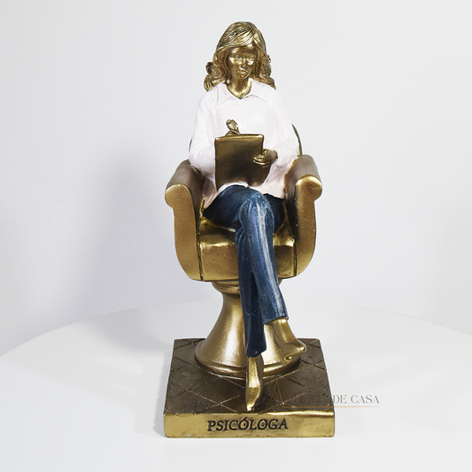 Escultura decorativa de psicóloga sentada em poltrona com prancheta, peça em resina ideal para decoração de consultório ou presente para psicóloga.