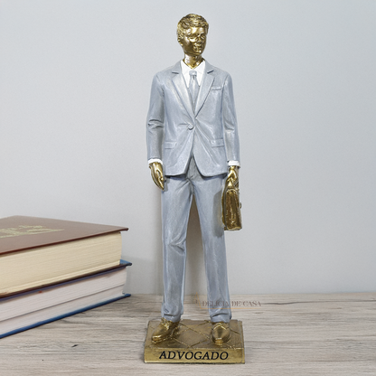 Estátua decorativa de advogado em resina dourada com pasta executiva, ideal para escritório e presente de formatura.
