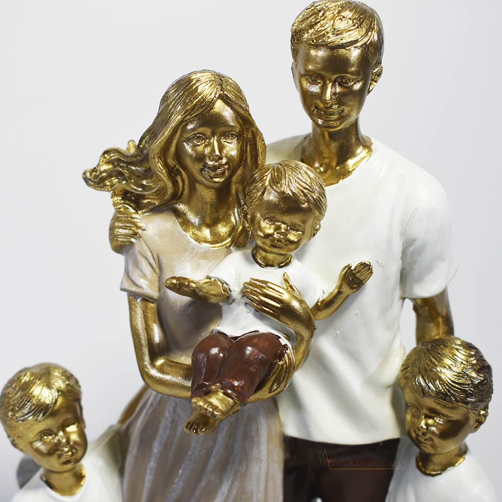 Escultura decorativa em resina representando família com pai, mãe e três filhos, acabamento dourado, branco e marrom, símbolo de amor, união e proteção familiar. Medidas de 25,5x17x8 cm.