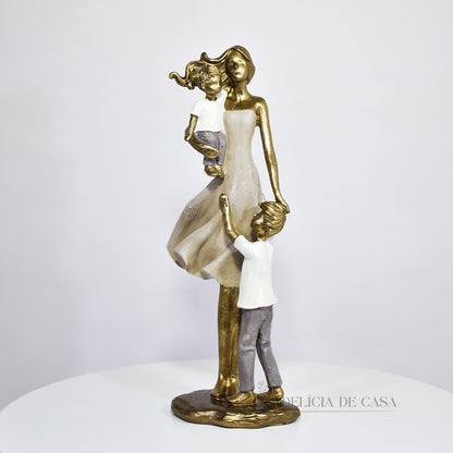 Escultura de mãe com dois filhos em resina dourada. Uma peça elegante e simbólica que representa o amor familiar, ideal para decorar ambientes ou presentear em ocasiões especiais.