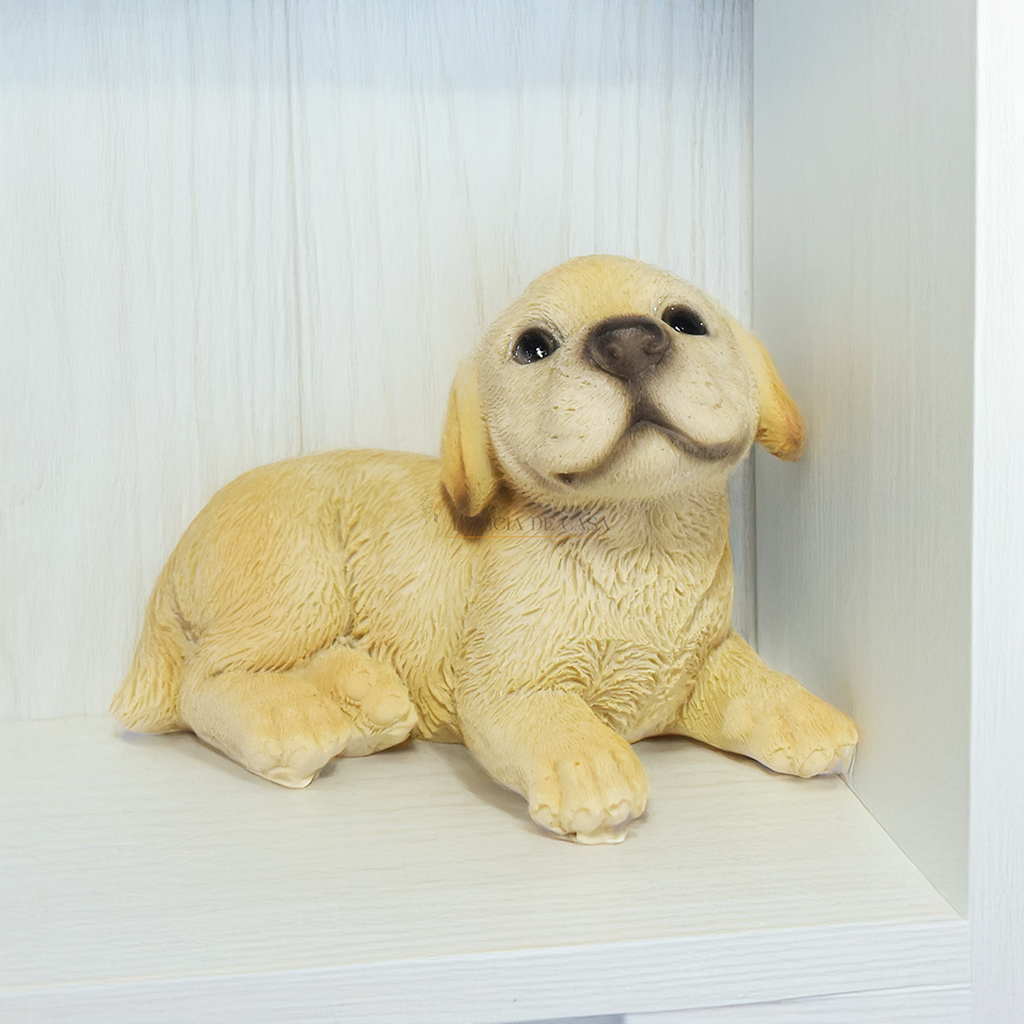 Três enfeites decorativos de cachorro Labrador em resina nas posições deitado, em pé e sentado sobre superfície branca