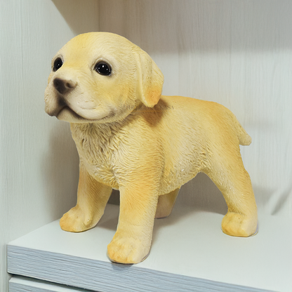 Três enfeites decorativos de cachorro Labrador em resina nas posições deitado, em pé e sentado sobre superfície branca