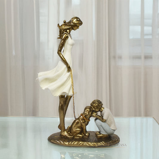 Estatueta decorativa de resina representando uma mãe segurando a coleira de um cachorro, enquanto seu filho se ajoelha e interage com o pet, simbolizando amor e conexão familiar.