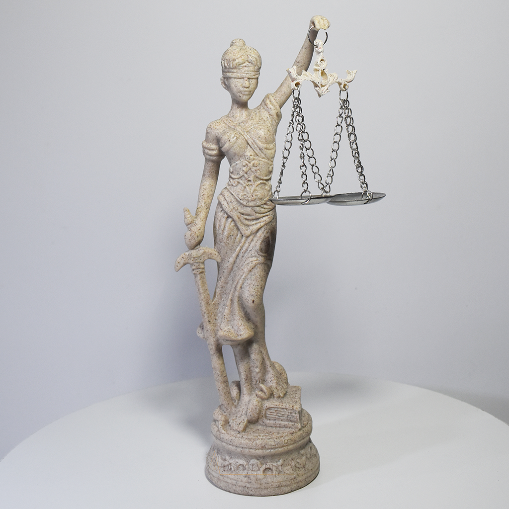 Escultura Dama da Justiça em resina com acabamento marmorizado, segurando espada e balança, símbolo clássico do Direito e da imparcialidade.