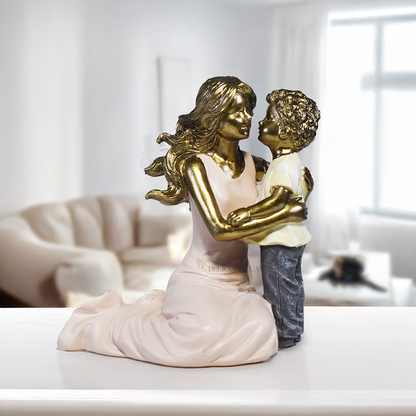 Escultura decorativa de mãe abraçando seu filho, confeccionada em resina com acabamento dourado, branco e cinza, medindo 11,5 x 11,5 x 8 cm.