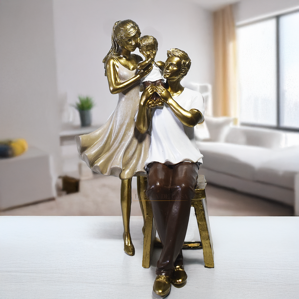 Escultura decorativa em resina representando pai sentado, mãe em pé e filho ao centro, simbolizando amor, proteção e união familiar.