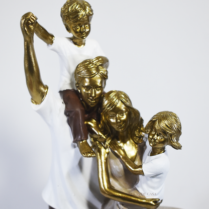 Escultura decorativa de família com pai, mãe, um filho e uma filha, confeccionada em resina com acabamento dourado, branco e marrom, medindo 29,5 x 14 x 8,5 cm.