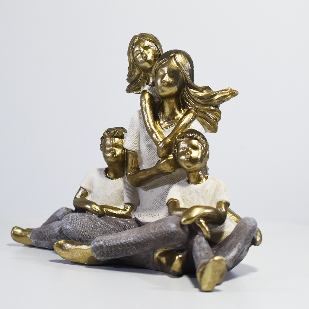 Escultura decorativa de mãe sentada com dois filhos e uma filha, confeccionada em resina com acabamento dourado, branco e cinza, medindo 15 x 11,5 x 8 cm.