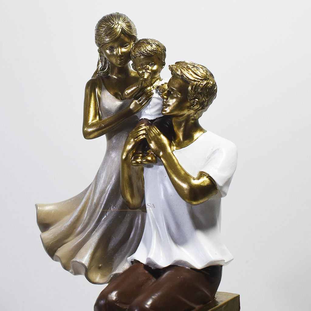 Escultura decorativa em resina representando pai sentado, mãe em pé e filho ao centro, simbolizando amor, proteção e união familiar.