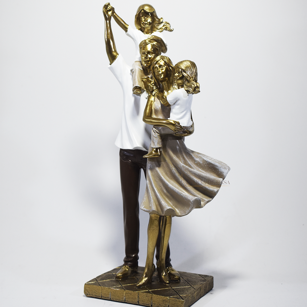Escultura decorativa em resina representando pai, mãe e duas filhas em uma composição elegante e harmoniosa, com acabamento dourado, branco e marrom, simbolizando amor, união e felicidade familiar. Medidas 29,5x14x8,5 cm.