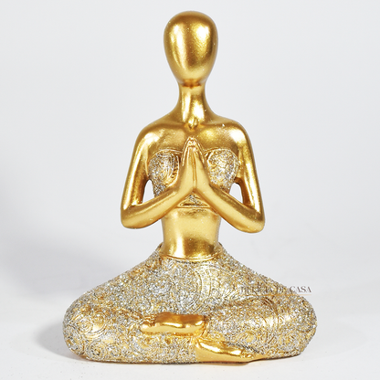 Trio de estátuas douradas com glitter representando posturas de ioga, ideal para decoração zen e ambientes de meditação.