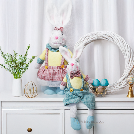Coelho decorativo de Páscoa em pelúcia sentado, com roupa em tons suaves, perfeito para decoração de casa e ambientes temáticos.
