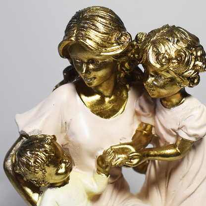 Escultura decorativa em resina representando mãe ajoelhada com dois filhos, simbolizando amor, cuidado, proteção e união familiar.