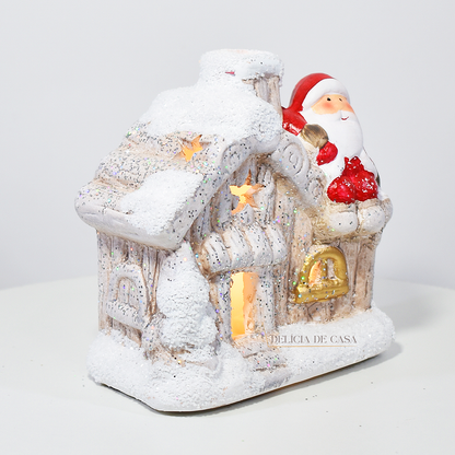 Casinha decorativa de Natal com Papai Noel e neve, feita em resina com glitter e luz interna, 12 cm de altura, nas cores bege, vermelho e cinza.