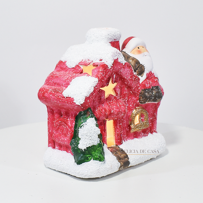 Casinha decorativa de Natal com Papai Noel e neve, feita em resina com glitter e luz interna, 12 cm de altura, nas cores bege, vermelho e cinza.