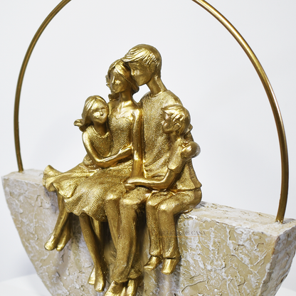 Estátua decorativa em resina dourada representando casal com filhos sentados em base artística, símbolo de união e amor familiar.