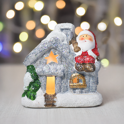 Casinha decorativa de Natal com Papai Noel e neve, feita em resina com glitter e luz interna, 12 cm de altura, nas cores bege, vermelho e cinza.