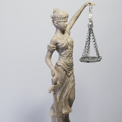 Escultura Dama da Justiça em resina com acabamento marmorizado, segurando espada e balança, símbolo clássico do Direito e da imparcialidade.