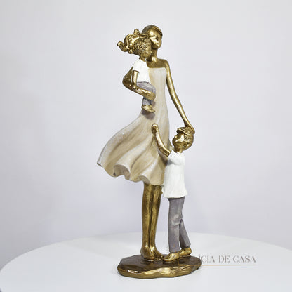 Escultura de mãe com dois filhos em resina dourada. Uma peça elegante e simbólica que representa o amor familiar, ideal para decorar ambientes ou presentear em ocasiões especiais.
