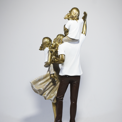 Escultura decorativa em resina representando pai, mãe e duas filhas em uma composição elegante e harmoniosa, com acabamento dourado, branco e marrom, simbolizando amor, união e felicidade familiar. Medidas 29,5x14x8,5 cm.