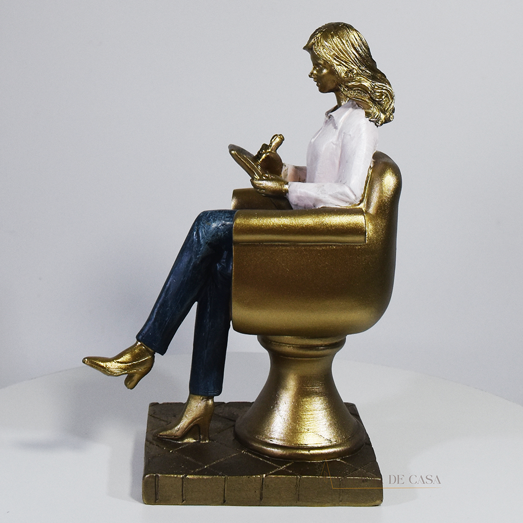 Escultura decorativa de psicóloga sentada em poltrona com prancheta, peça em resina ideal para decoração de consultório ou presente para psicóloga.