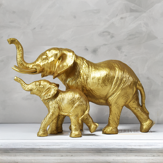 Escultura decorativa de elefante com filhote em resina dourada, simbolizando proteção, união familiar e prosperidade.