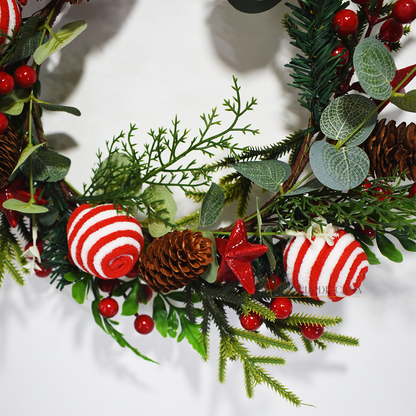 Guirlanda de Natal decorativa com bolas vermelhas e brancas, pinhas e folhagens verdes, ideal para pendurar na porta ou parede e decorar a casa no Natal.