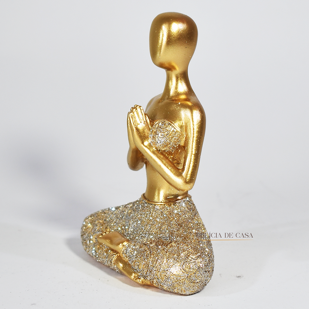 Trio de estátuas douradas com glitter representando posturas de ioga, ideal para decoração zen e ambientes de meditação.