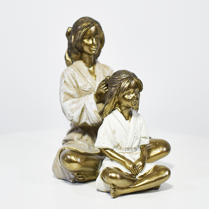 Escultura decorativa mãe e filha em resina dourada, peça elegante e simbólica para decoração de sala, quarto ou estante.